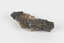 Hand-length specimen of black, brown, gold and beige mineral forming a jagged pipe shape. 