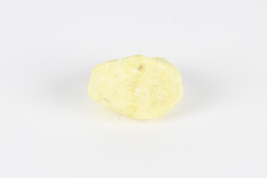 A small solid crystalline mineral specimen that is largely light yellow, with one darker spot. 