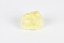 A small solid crystalline mineral specimen that is largely light yellow, with some darkening near top. 