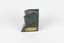 Solid mineral specimen of smooth grey-green rock with pale veins and mottling, marked with a gold sticker that reads "N.Z. Greenstone/ a product of/ Hokitika Jade Coy."