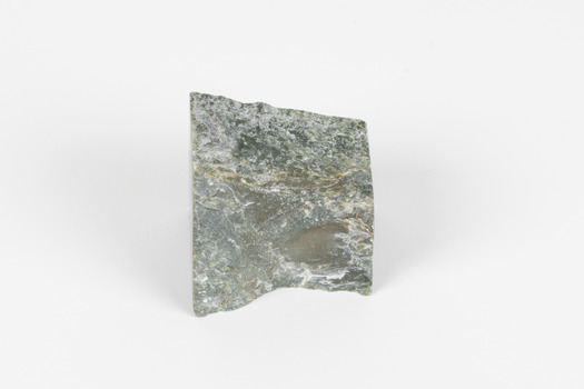 A small mineral specimen of grey-green stone with white and brown veins. 