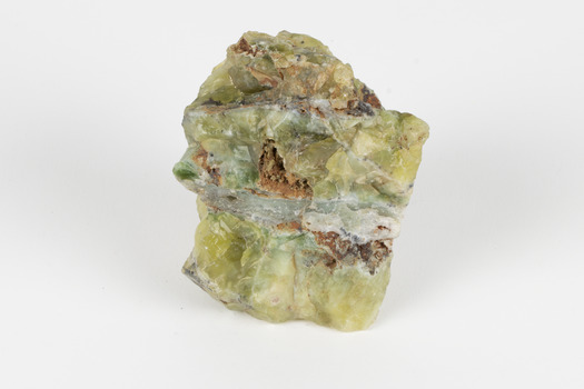 A solid mineral specimen in shades of yellow and gray-green, with a wide vein of pale grey running through the centre. 