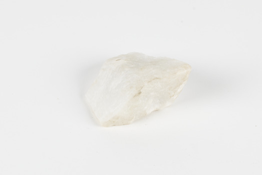 A hand-sized solid rock specimen in shades of white 