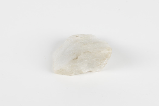 A hand-sized solid rock specimen in shades of white 