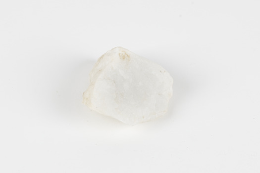 A hand-sized solid rock specimen in shades of white 