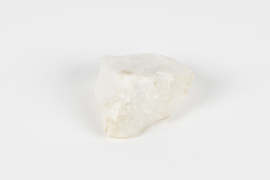 A hand-sized solid rock specimen in shades of white 