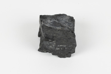 A hand-sized solid black-coloured specimen with jagged edges.