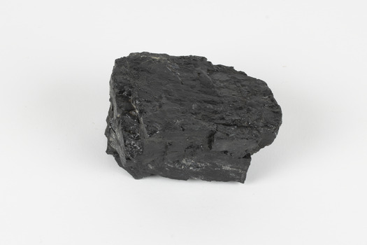 A hand-sized solid black-coloured specimen with jagged edges.