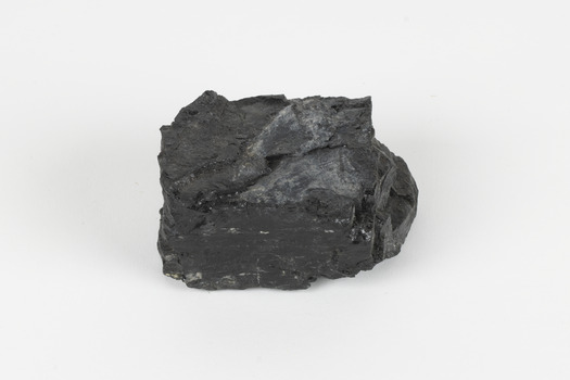 A hand-sized solid black-coloured specimen with jagged edges.