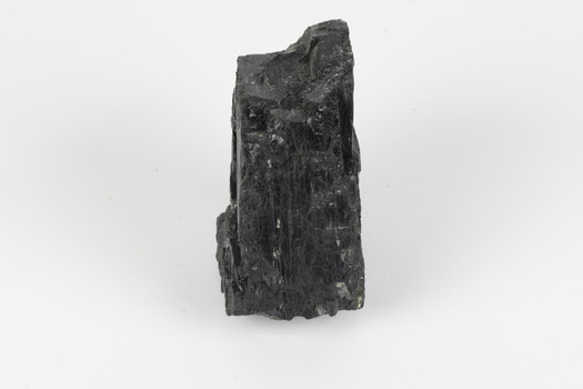 A hand-sized solid black-coloured specimen with jagged edges.