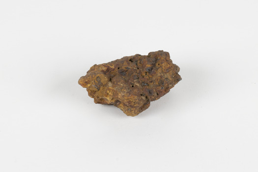 a palm-sized solid mineral specimen in shades of brown, orange and grey