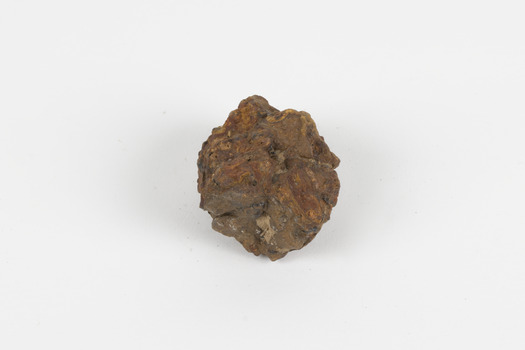 a palm-sized solid mineral specimen in shades of brown, orange and grey