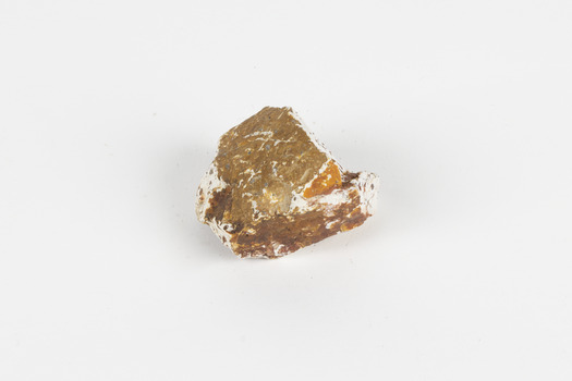 A mineral specimen that is about the size of a tennis ball coloured white, orange and brown