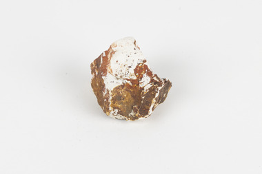 A mineral specimen that is about the size of a tennis ball coloured white, orange and brown