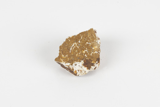 A mineral specimen that is about the size of a tennis ball coloured white, orange and brown