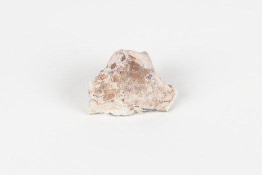 A palm-sized solid mineral specimen in shades of beige and light orange