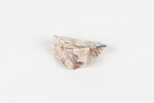 A palm-sized solid mineral specimen in shades of beige and light orange