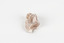 A palm-sized solid mineral specimen in shades of beige and light orange