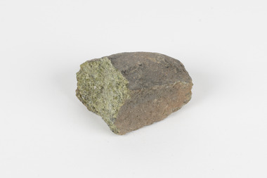 A hand-sized solid mineral specimen in shades of brown and green 