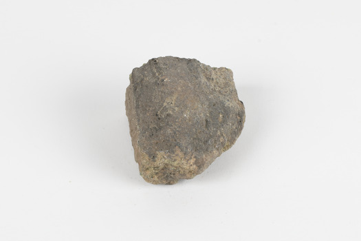 A hand-sized solid mineral specimen in shades of brown and green 