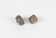 Two pieces of separate mineral specimen in shades of grey, brown, and yellow with crosses in the center