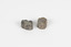 Two pieces of separate mineral specimen in shades of grey, brown, and yellow with crosses in the center