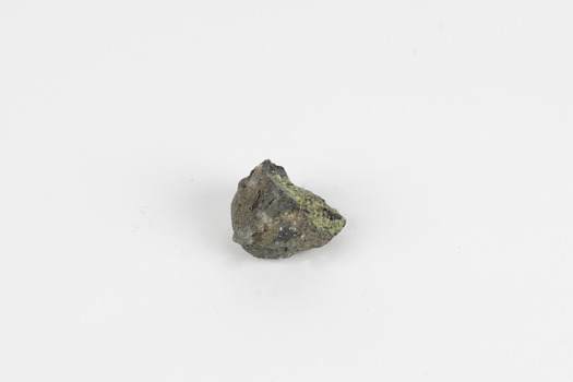 A solid mineral specimen in shades of green, grey and brown with the centre of the mineral exposed