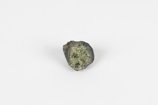 A solid mineral specimen in shades of green, grey and brown with the centre of the mineral exposed