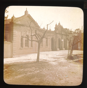 A monochrome photograph within a round-edged square frame depicting the Ovens District Hospital in Beechworth as it appeared in approximately 1900. 