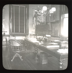 A monochrome photograph within a square frame featuring an image of an office.