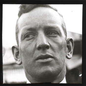 A monochrome photograph within a square frame featuring a close-up image of a man's face.