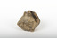 A small textured caramel-coloured granite rock with brown marbling. On the upper right side is an oblong indentation revealing shiny deep brown to black layer.