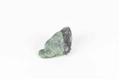 A small solid mineral specimen that is primarily pale green and blue-grey with speckles of beige and white.