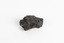 A small solid mineral specimen that is blue-grey in colour with rust brown specks throughout.