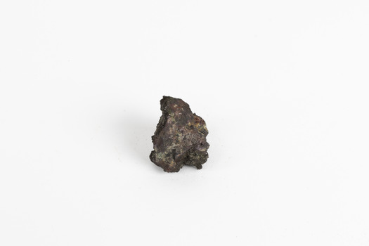 A small, palm-sized solid mineral specimen with shades of browns, black and copper tones