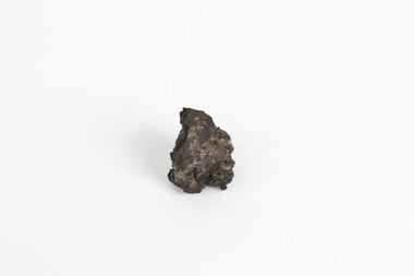 A small, palm-sized solid mineral specimen with shades of browns, black and copper tones