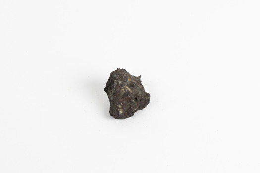 A small, palm-sized solid mineral specimen with shades of browns, black and copper tones