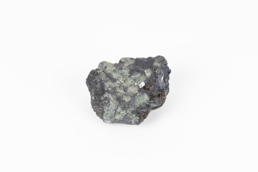 Palm-sized mineral of primarily grey colour, small red gemstones visible, green patches.