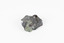 Palm-sized mineral of primarily grey colour, small red gemstones visible, green patches.