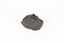 Coin-sized solid mineral specimen in sades of back and red with black shiny points.