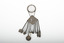 A decorative silver belt hook with small household object attached by chains to a suspended name plate