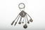 A decorative silver belt hook with small household object attached by chains to a suspended name plate