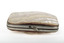 The top of a small rectangular purse with silver edging and half clasp, covered in white and cream coloured shell.