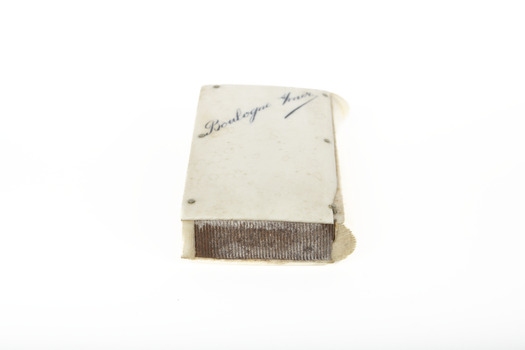 A small white rectangular box with cursive writing on top.
