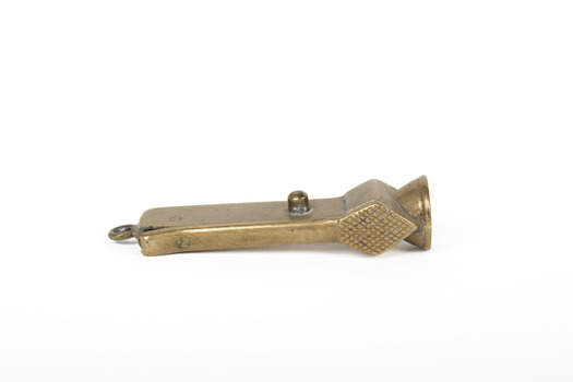 Small bronze metallic cigar cutter positioned on side exposing back with back of cigar insert on the right side of the object and a small round notch below cigar insert showing slight patina. . . 