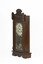 Angled view of front of a deep brown wooden striking mantle clock from right perspective. Clock features decorative carvings and a glass door with black, gold, and red etched detail. The clock face is white with gold rims and black roman numerals marked.