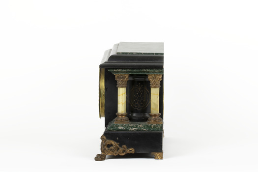 Side view of a Seth Thomas black mantle clock with green marbling detail. The clock also features ornate gold claw feet and fine gold painted detailing. From this angle, the front and rear white pillars are visible.