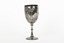 Silver cup in the shape of a wine glass, as the cup tapers to a pedestal. The cup is engraved with branches and leaves, the base engraved with lines, dots and a half-moo pattern. 