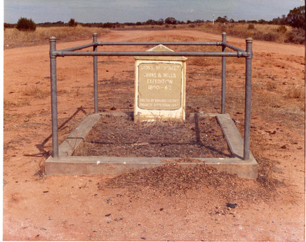 Desert grave stone of Dost Mahomet surrounded by singular pipe fence.