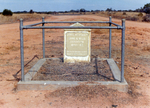 Desert grave stone of Dost Mahomet surrounded by singular pipe fence.